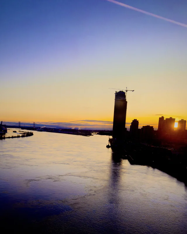 A river under an evening sky, a tower on the far bank