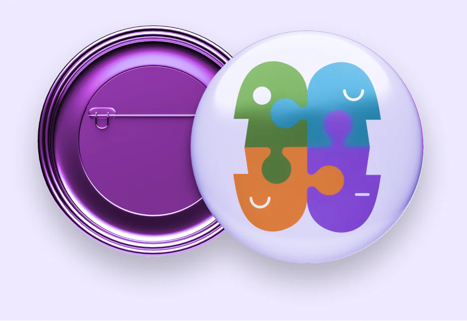 A purple badge pin and a pearly one showing two puzzle-piece heads.