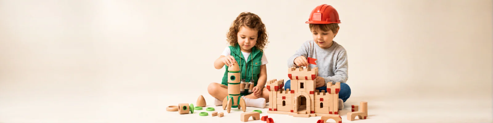 Children building with wooden TWIGIT blocks and gears at a workshop table.